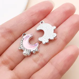 Nahaufnahme von rosa schimmerndem Halbmond-Anhänger mit Strass und Perle