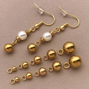 Nahaufnahme goldener Edelstahlperlen mit Öse für die kreative DIY-Schmuckherstellung