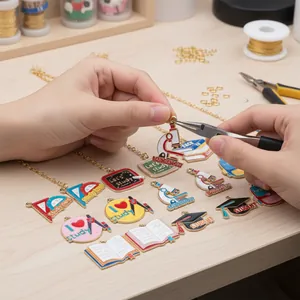 Hand-assembled DIY enamel charms with school and graduation motifs on a gold chain