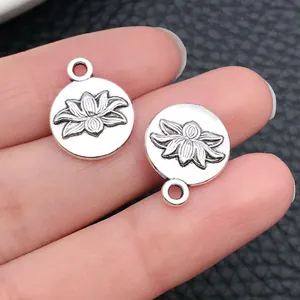 Vue rapprochée détaillée de breloques lotus en argent antique pour création de bijoux