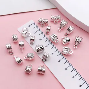 Detailed macro view of silver retro patterned jewelry bails with ruler for size scale