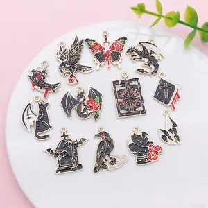 Macro view of Gothic style dark enamel charms with dragon and butterfly motifs.