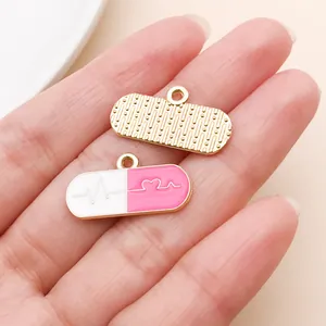 Macro view of pink and white pill-shaped enamel charms with heartbeat line pattern
