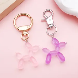 Detailansicht von rosa und violetten durchscheinenden Ballonhund-Anhängern mit Ringen.