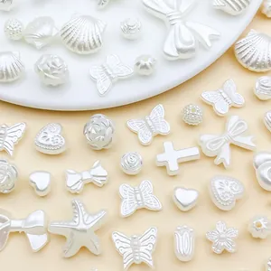 Nahaufnahme von cremeweißen ABS-Perlen in verschiedenen Formen für DIY-Schmuck