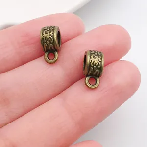 Close-up of vintage bronze alloy bails with intricate floral patterns for DIY jewelry
