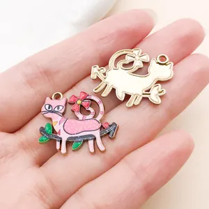 Close-up of pink enamel floral cat and gold-toned mother-baby charms for DIY jewelry