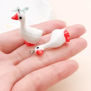 Dichtbij van mini witte gans hars bedeltjes voor DIY sieraden in de hand
