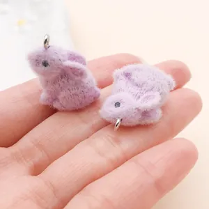 Détail macro de deux breloques lapins miniatures floqués violets pour le bricolage