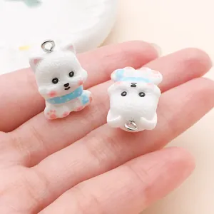 Close-up of white 3D cartoon dog charms with blue collars for DIY jewelry making