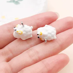 Close-up van twee witte hars schaapjes met metalen ringen in de palm van een hand