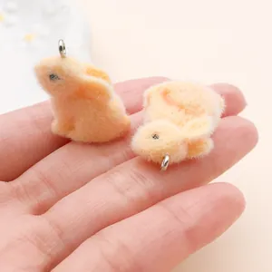 Gros plan de breloques lapins pêche duveteux montrant leur texture floquée.