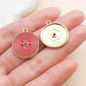 Gros plan d'un pendentif disque vinyle rouge élégant pour la création de bijoux DIY.