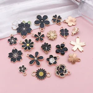 Assortment of black enamel flower charms including rose, daisy, and cherry blossom shapes.