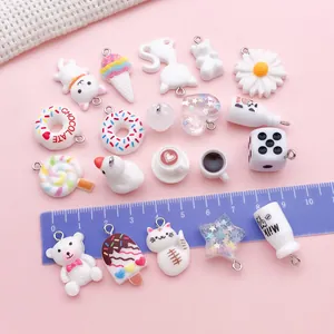 Macro detail of various white resin charms featuring cute animals and food for DIY jewelry