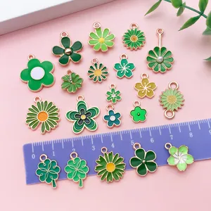 Variété de breloques en émail vert fleurs et trèfles pour bijoux DIY avec une règle