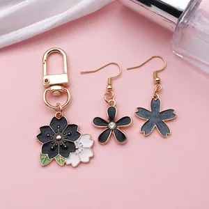 Detailed view of black enamel cherry blossom and flower charms for DIY jewelry