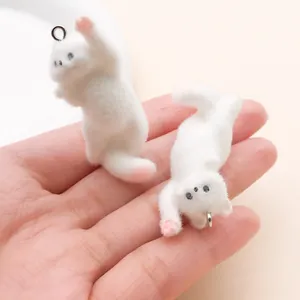 Detalle de primer plano de dos pequeños dijes de gatitos blancos para manualidades