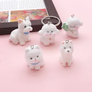 Vista macro de cinco dijes de perro flocados blancos para accesorios de llaveros DIY
