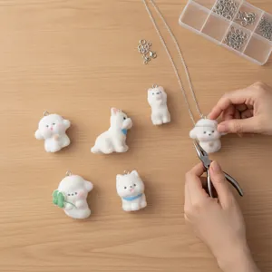 Escena de creación de joyas DIY con colgantes de perro flocados blancos y herramientas