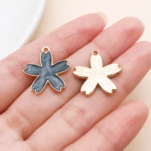 Close-up showing detail of black enamel and rose gold cherry blossom flower charms
