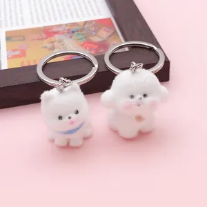 Primer plano de llaveros de cachorros blancos flocados en estilos Westie y Bichon