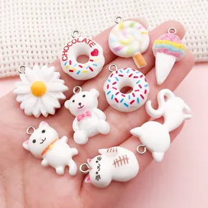 Close-up of white resin charms in food and animal shapes for DIY jewelry making