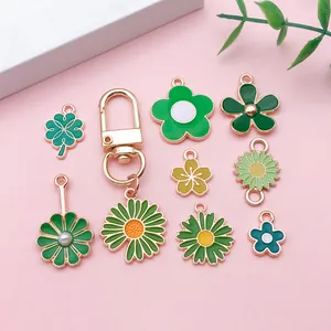 Vue détaillée des breloques émaillées fleurs vertes et porte-clés doré à fermoir