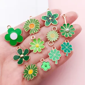 Gros plan de divers pendentifs en émail vert en forme de fleur et trèfle porte-bonheur
