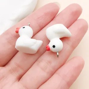 Macro view of cute white resin little duck charms for DIY jewelry and keychain accessories