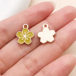 Gros plan d'un pendentif fleur en émail vert montrant les détails recto-verso pour bijoux DIY.