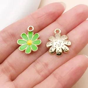 Gros plan de breloques fleurs en émail vert avec finition dorée pour la création de bijoux