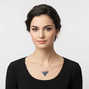 Vue détaillée d'un pendentif colibri coloré sur une chaîne porté par un mannequin.