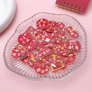 Close-up detail of red graduation alloy charms with various Chinese blessing slogans in a bowl