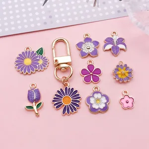 Gros plan détaillé de divers pendentifs en fleurs émaillées violettes et tulipes