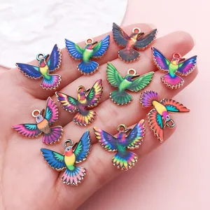 Détail de breloques colibris en émail coloré pour la fabrication de bijoux DIY créatifs.