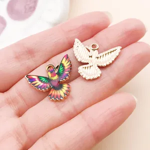 Vue détaillée de breloques colibris en émail coloré et en or pour la création de bijoux.