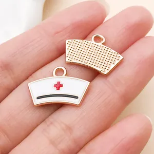 Detailansicht eines weiß-goldenen Emaille-Krankenschwesterhut-Anhängers für DIY-Schmuck