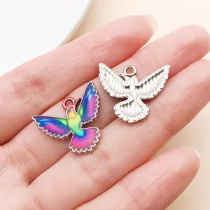 Close-up of colorful printed hummingbird and silver bird charms for DIY jewelry making