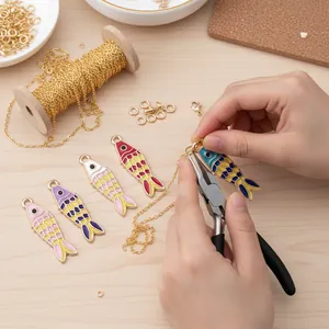Detailed view of handmade DIY necklace creation using colorful enamel koi fish charms.