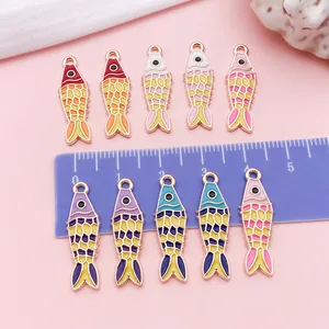 Detailed view of colorful koi fish enamel charms with ruler for size reference