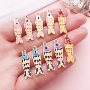 Colorful enamel koi fish alloy charms for DIY jewelry making displayed on a hand