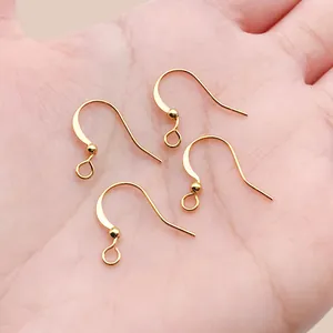 Detail view of four 18k gold plated copper earring hooks shown on a palm for scale