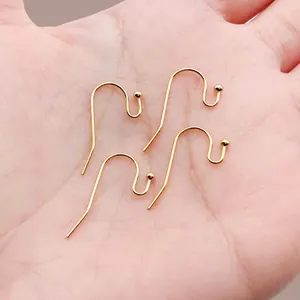 Close-up of four 18k gold-plated earring hooks with ball ends for jewelry making
