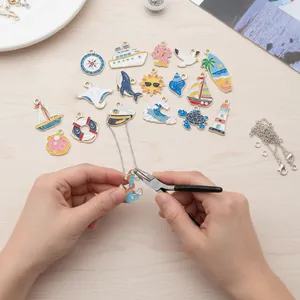 Detailansicht der Hände, die nautische Emaille-Anhänger für DIY-Schmuck zusammenbauen