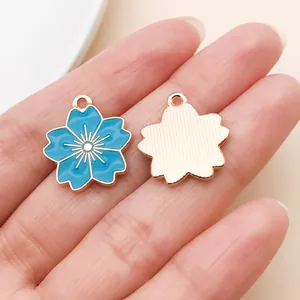 Gedetailleerd overzicht van meerblauwe kersenbloesem emaille bedeltjes voor DIY sieraden