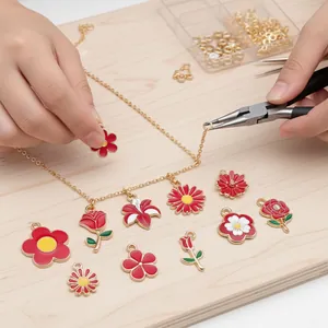 Gedetailleerd overzicht van DIY sieraden maken met rode emaille bloemen en gouden ketting.