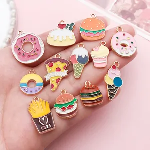Close-up of colorful enamel food charms including pizza, donuts, and burgers in hand