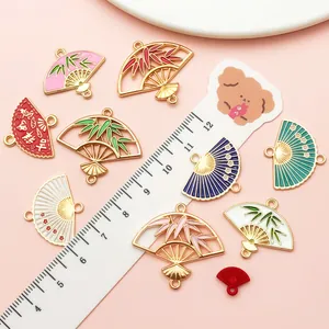 Detail of Chinese style enamel fan charms showing various patterns and size scale