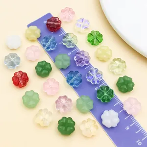 Primer plano de cuentas de vidrio trébol de 10mm de colores junto a una regla morada
